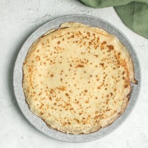 Somali malawah crepe with golden-brown spots, served on a gray plate.
