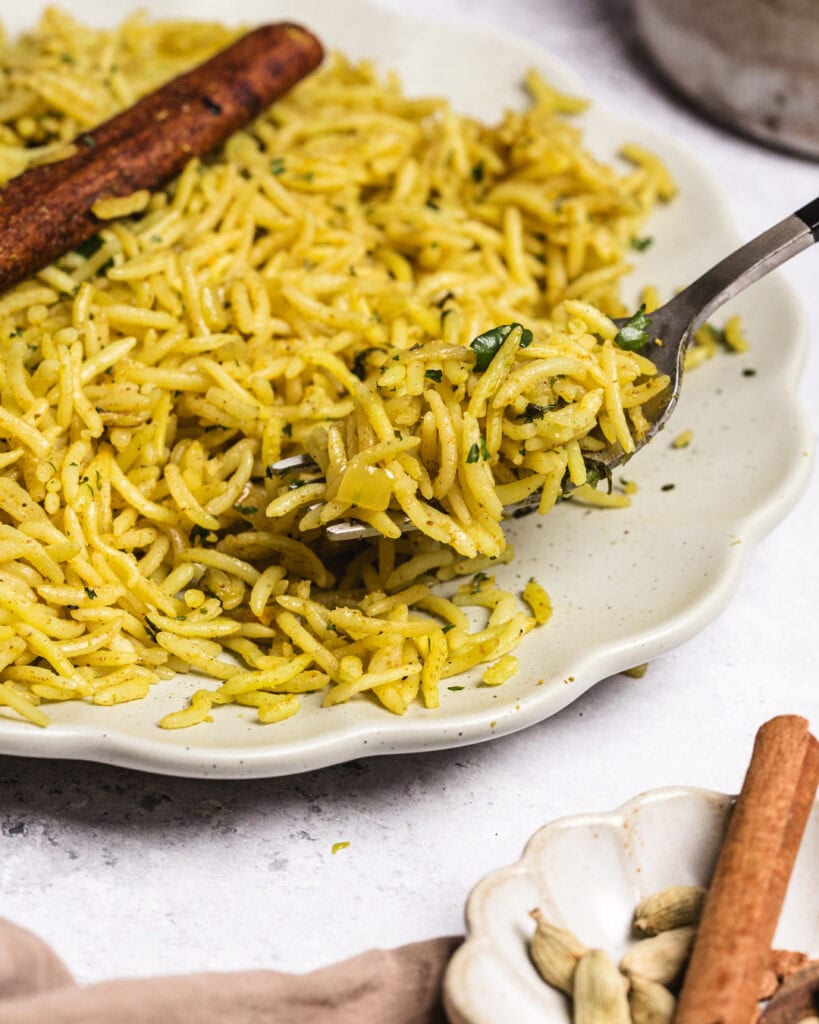 Delicious Somali rice dish with spices and herbs, served with cinnamon sticks.