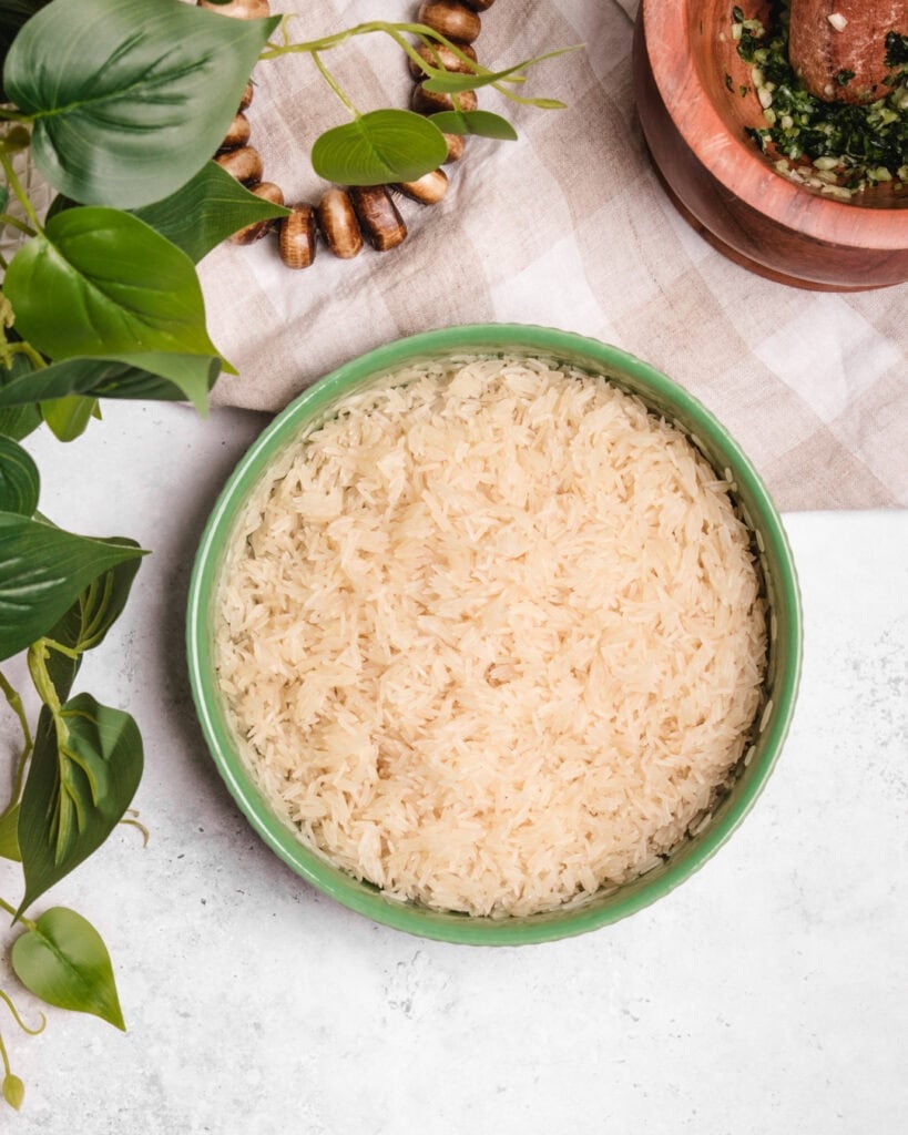 A bowl of fluffy Somali rice with a light, tender texture, served in a green ceramic dish.