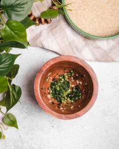 A bowl of Somali Bariis with chopped herbs and spices, ready to serve.