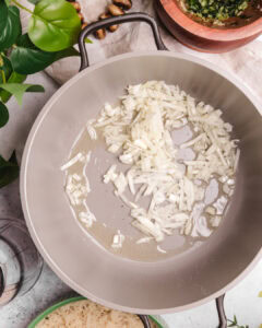 Sautéed chopped onions in a frying pan, ready for Somali rice dish.