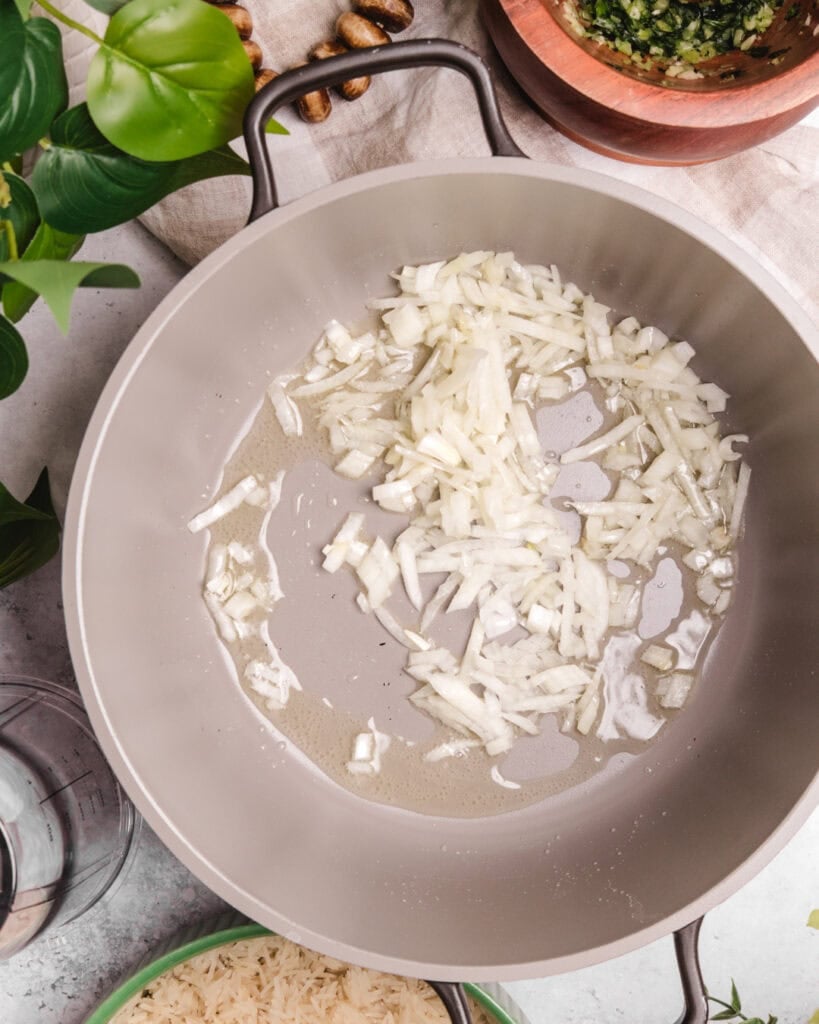 Sautéed chopped onions in a frying pan, ready for Somali rice dish.