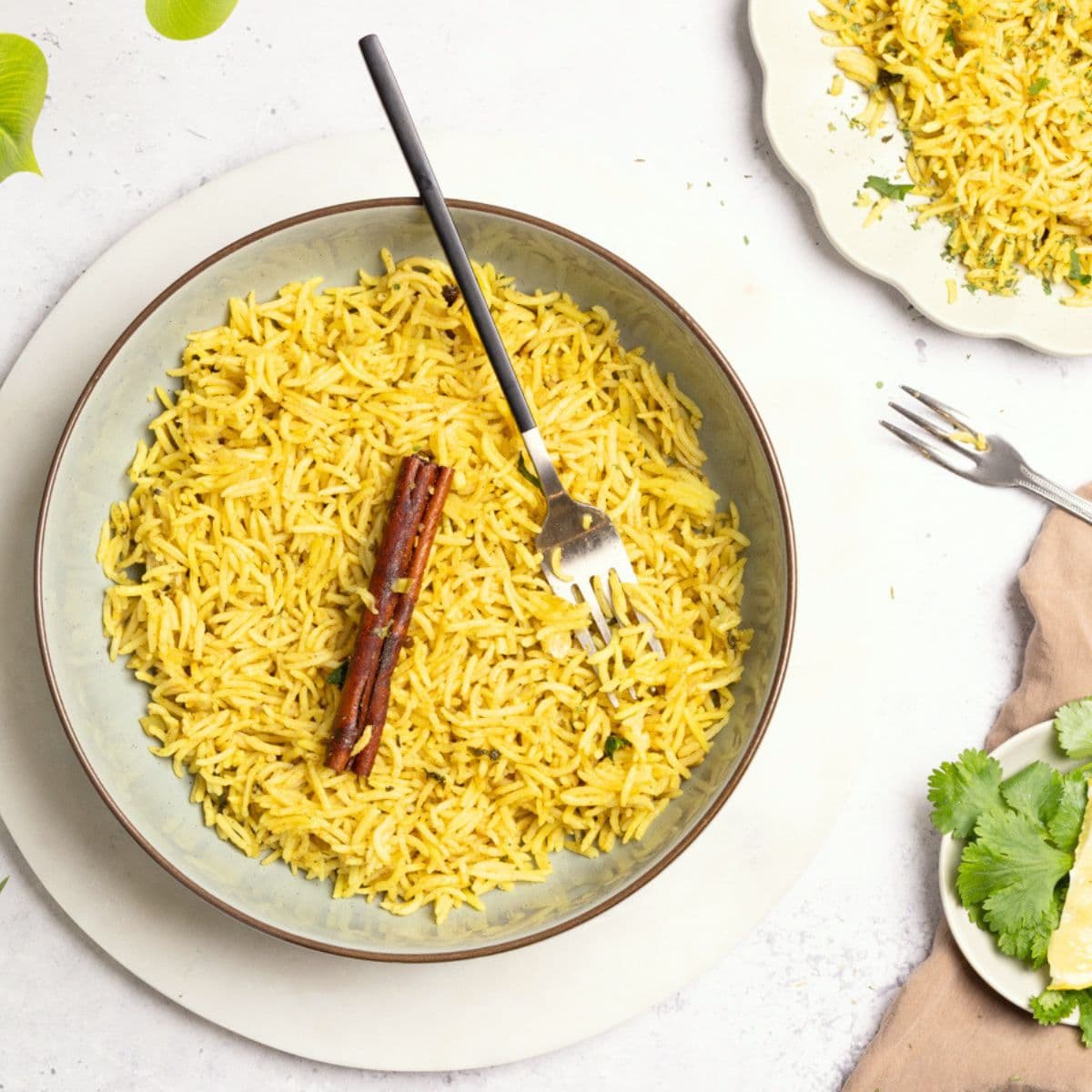 A bowl of Somali Bariis rice garnished with a cinnamon stick and a fork.