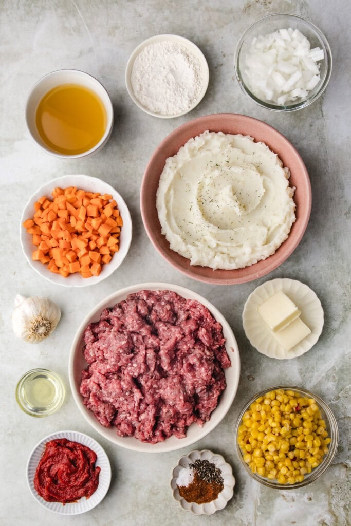Assorted ingredients including ground meat, mashed potatoes, vegetables, and seasonings.
