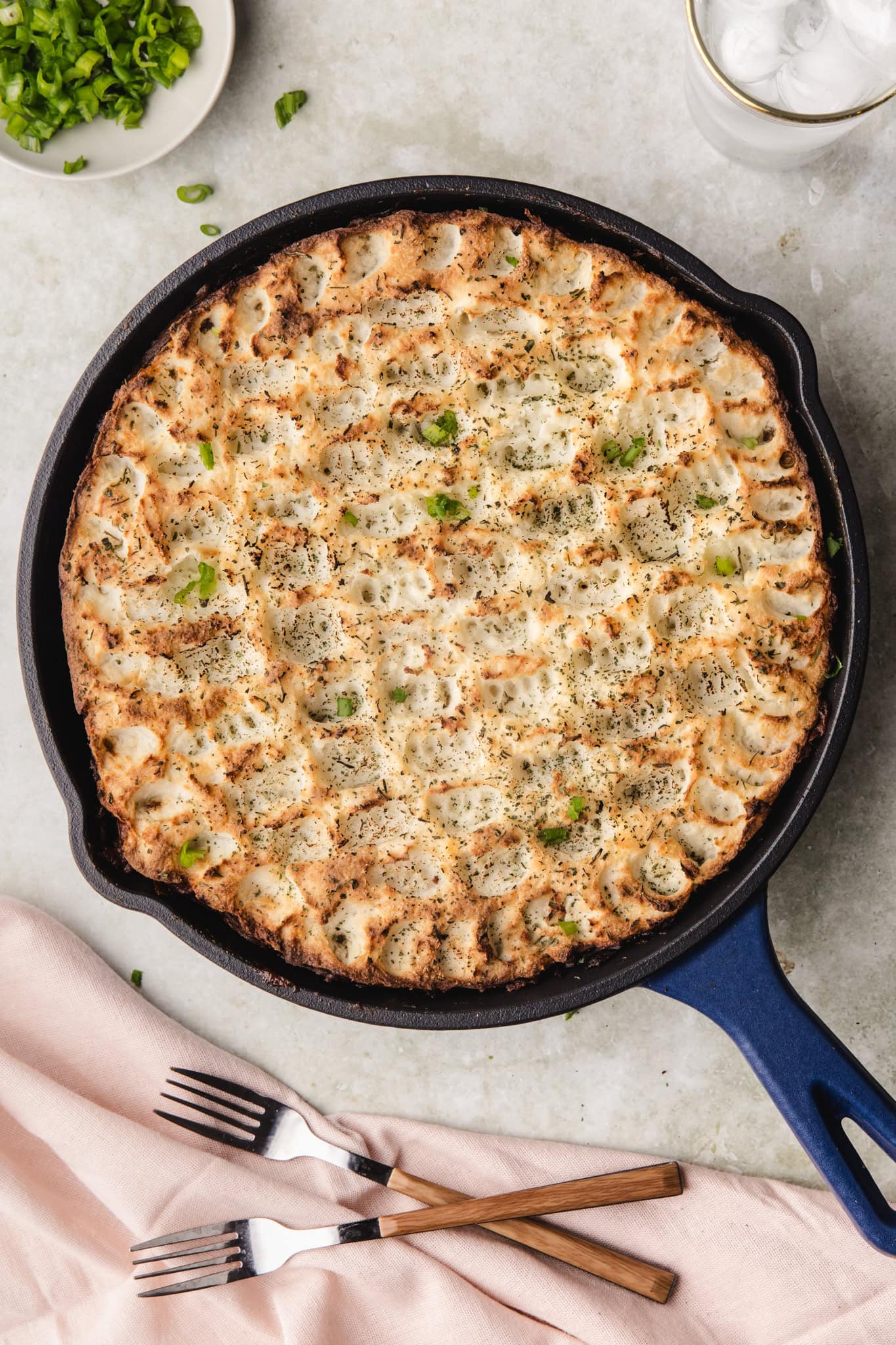 Baked casserole with chicken, broccoli, and melted cheese in a skillet.
